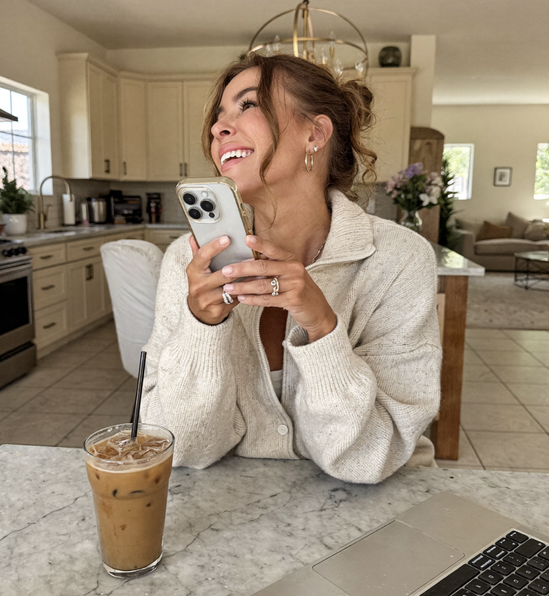 Morgan smiling at her kitchen counter holding her phone